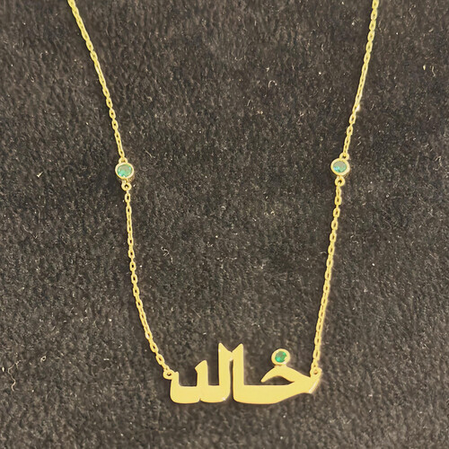 سلسلة ذهب عيار ١٨ باسم هالد مع نقط زجاج خضرااء