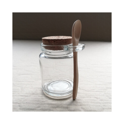 وعاء زجاج مع غطاء وملعقة خشب